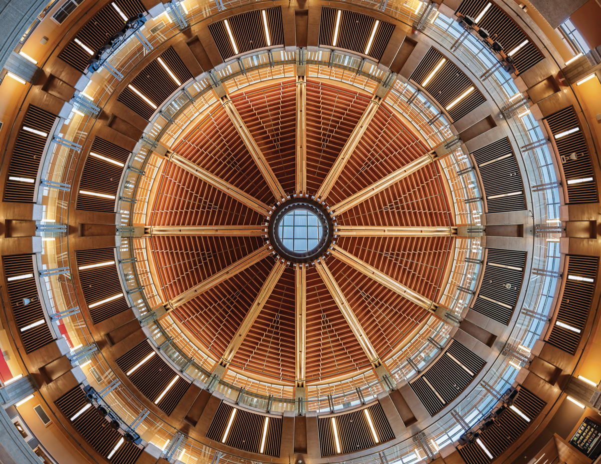 Glue-laminated timber (Glulam), paneling, plywood, and solid-sawn heavy timbers were combined to create the concentric circles shown in this upward interior image of the Abbotsford Senior Secondary School ceiling