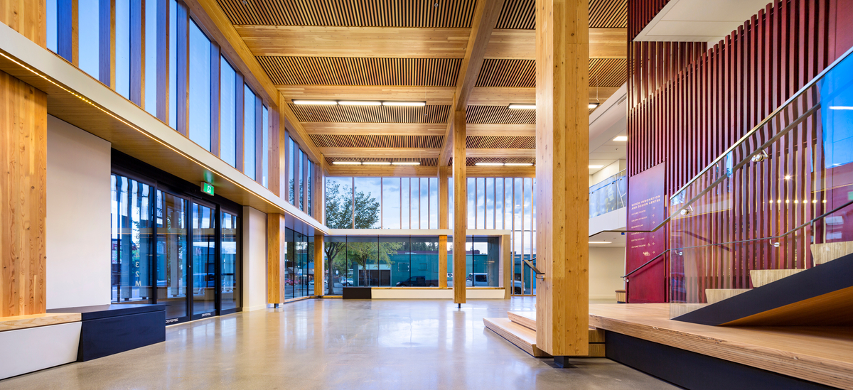 Interior afternoon view showing entrance and lobby atrium of six storey Wood Innovation and Design Centre complete with Glue-laminated timber (Glulam) columns supporting Cross-laminated timber (CLT) ceiling sections